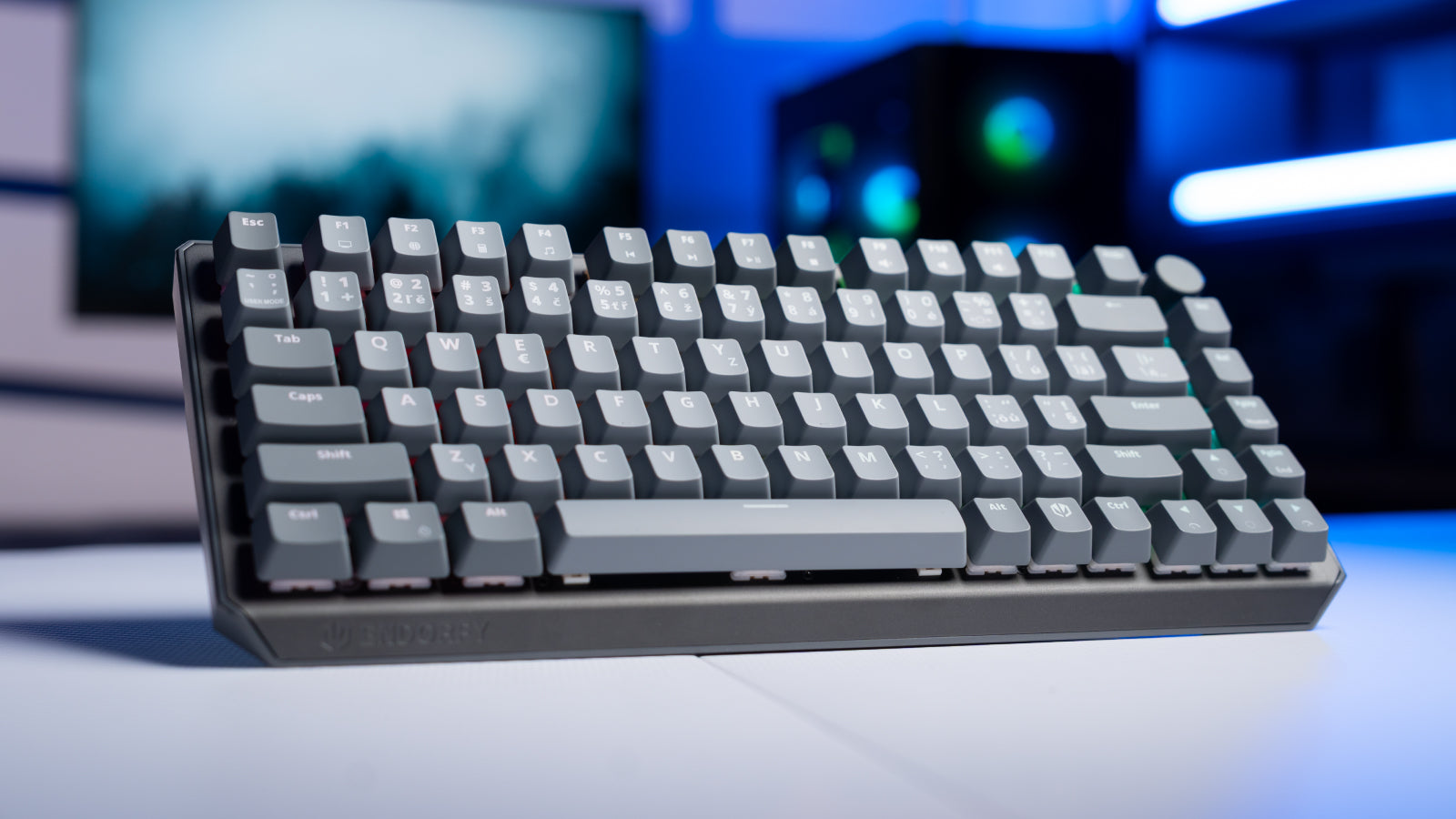 Klawiatura ENDORFY Thock V2 75% Wireless stoi na biurku, a w tle widać komputer