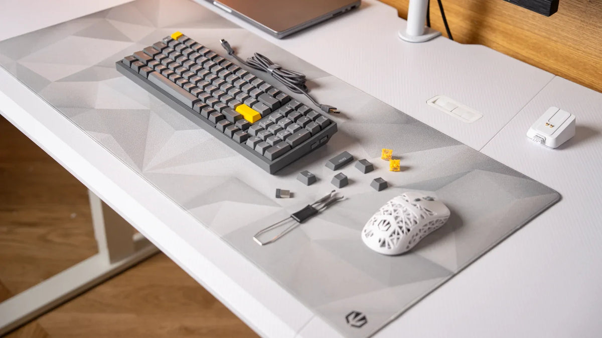 Klawiatura ENDORFY Celeris 1800 i mysz ENDORFY LIV Plus Wireless Onyx White na podkładce ENDORFY Crystal Onyx White XL, obok zdjęte keycapy, przełączniki i puller