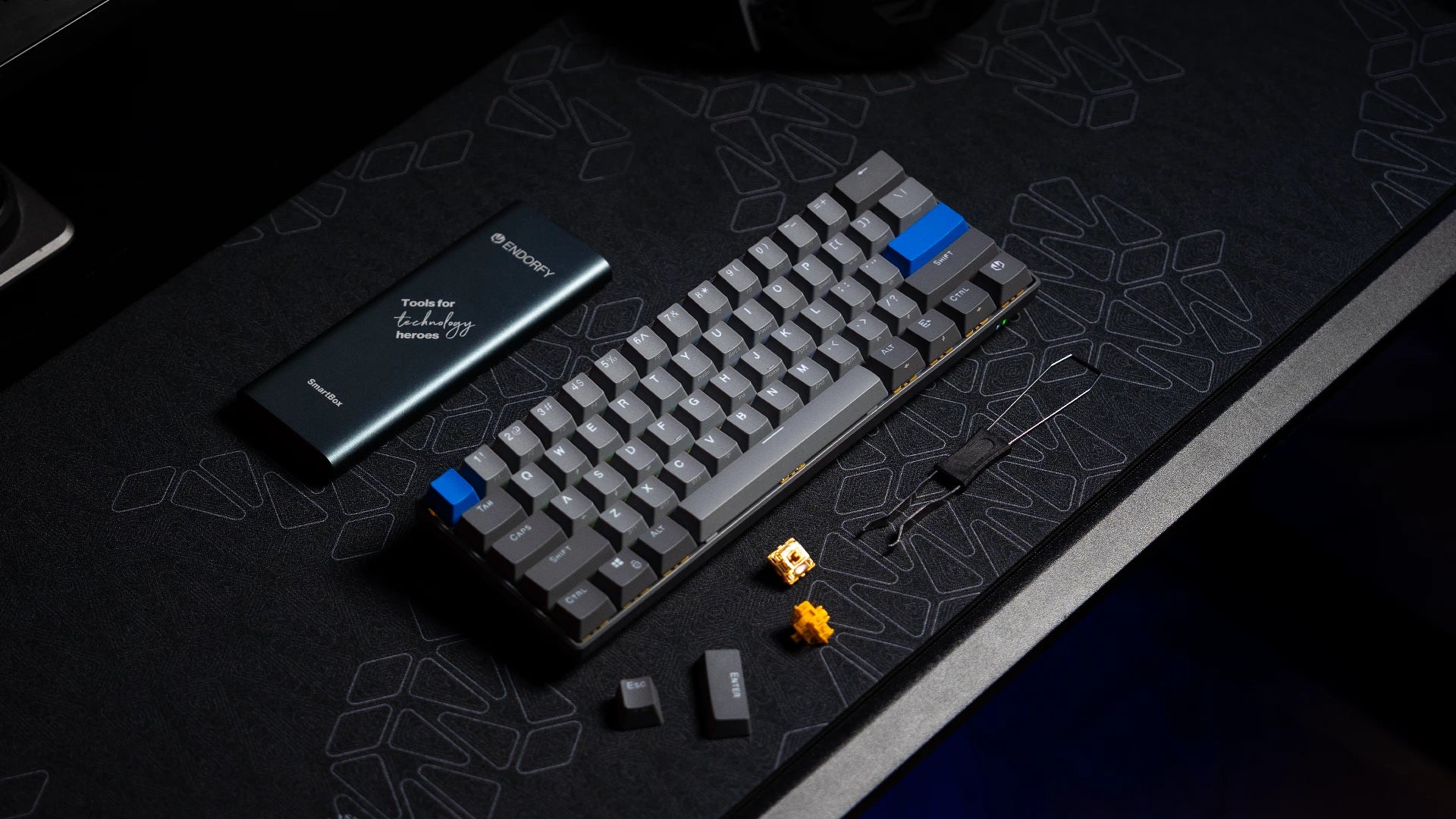 Klawiatura ENDORFY Thock V2 Compact Wireless na biurku z narzędziem do wyjmowania keycapów i hotwappowania switchy – obok widoczne zapasowe keycapy i switch 