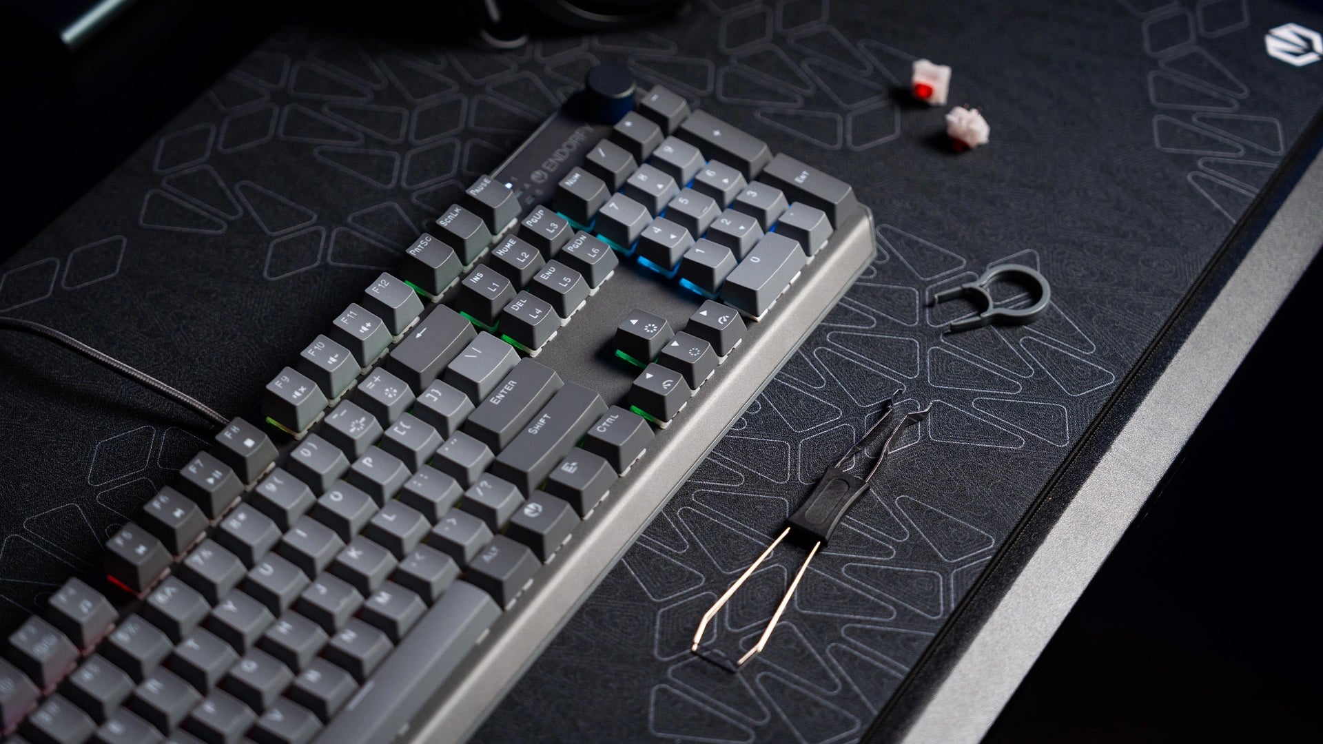 Klawiatura ENDORFY Thock V2 DE na biurku z narzędziem do wyjmowania keycapów i hotswappowania switchy – obok widoczne zapasowe keycapy i switch 