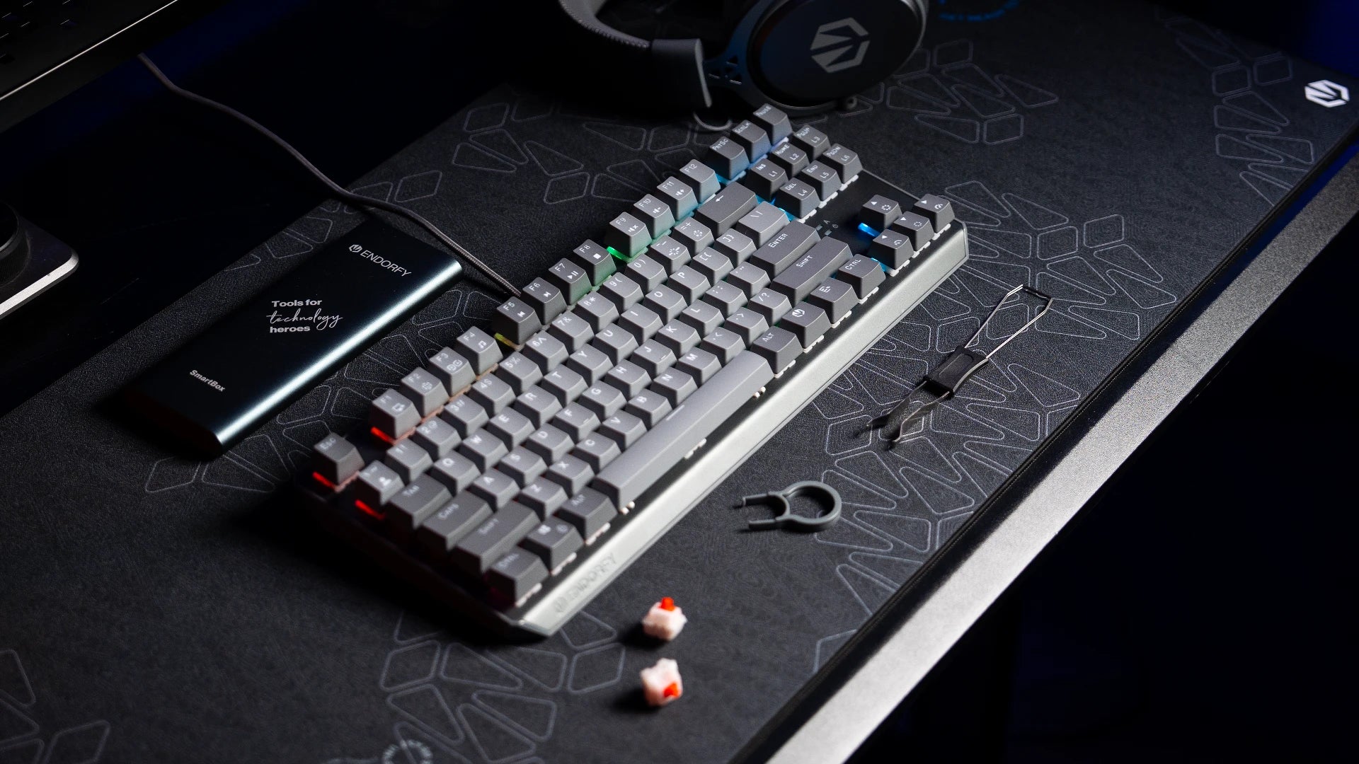 Klawiatura ENDORFY Thock V2 TKL DE na biurku z narzędziem do wyjmowania keycapów i hotswappowania switchy – obok widoczne zapasowe keycapy i switch 