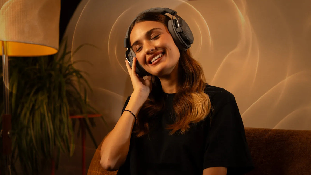 Woman wearing ENDORFY Viro Wireless headphones and touching the right earcup