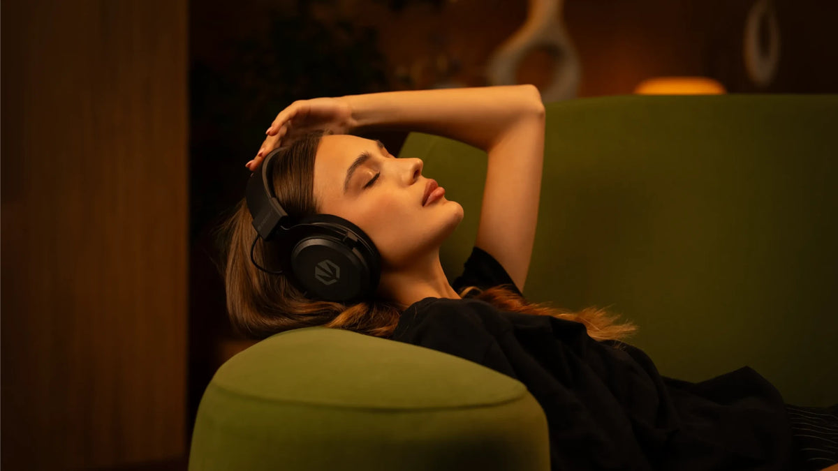 Woman resting on a sofa while wearing the ENDORFY Viro Infra Wireless headphones