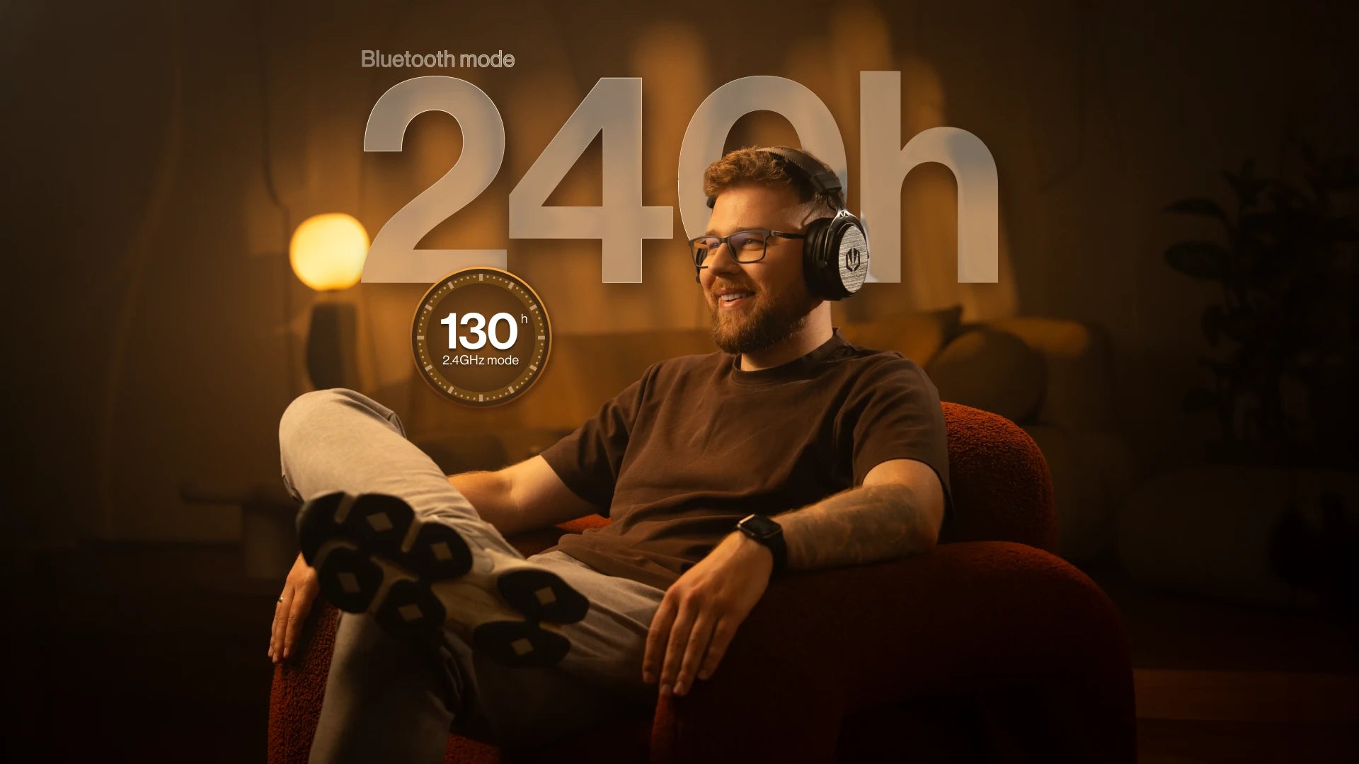 A model sitting in an armchair wearing ENDORFY Viro Wireless headphones