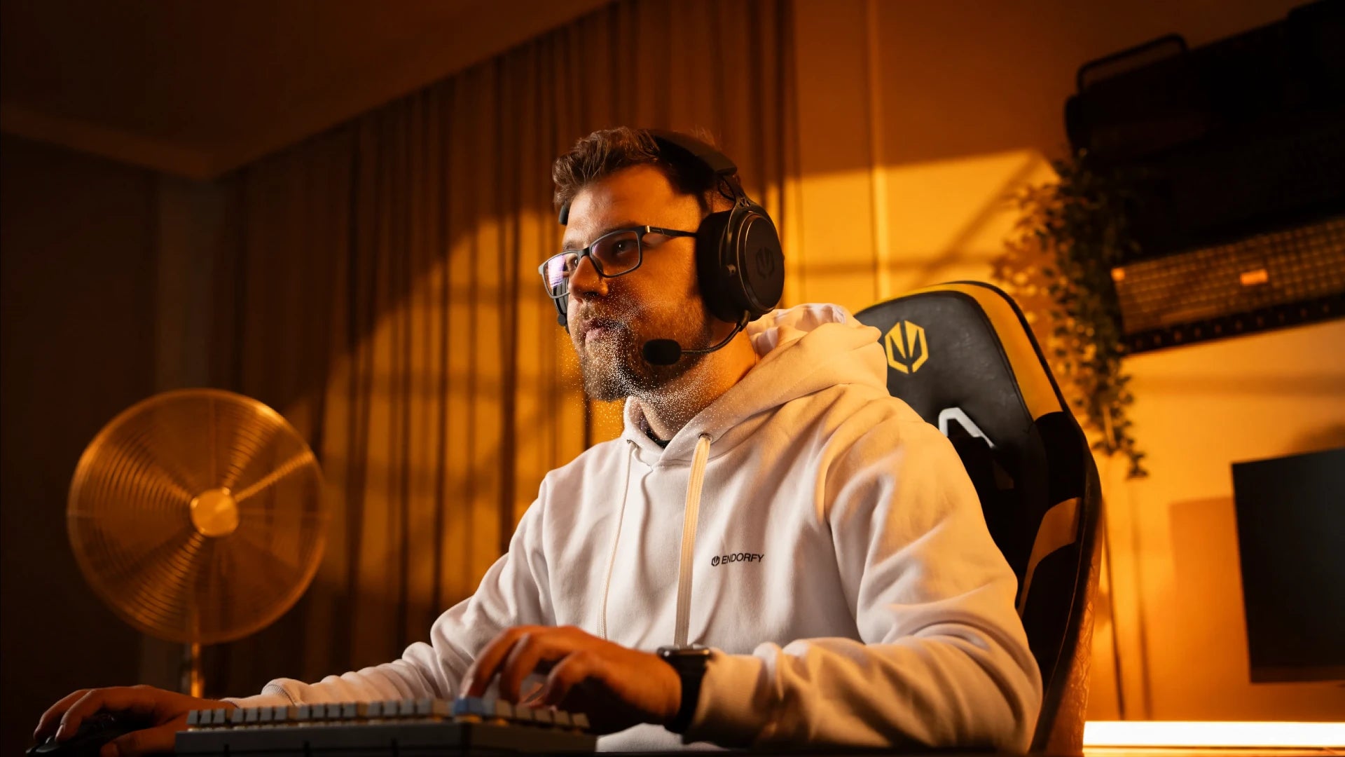 A model using ENDORFY Viro Wireless headphones with the microphone attached while using a computer