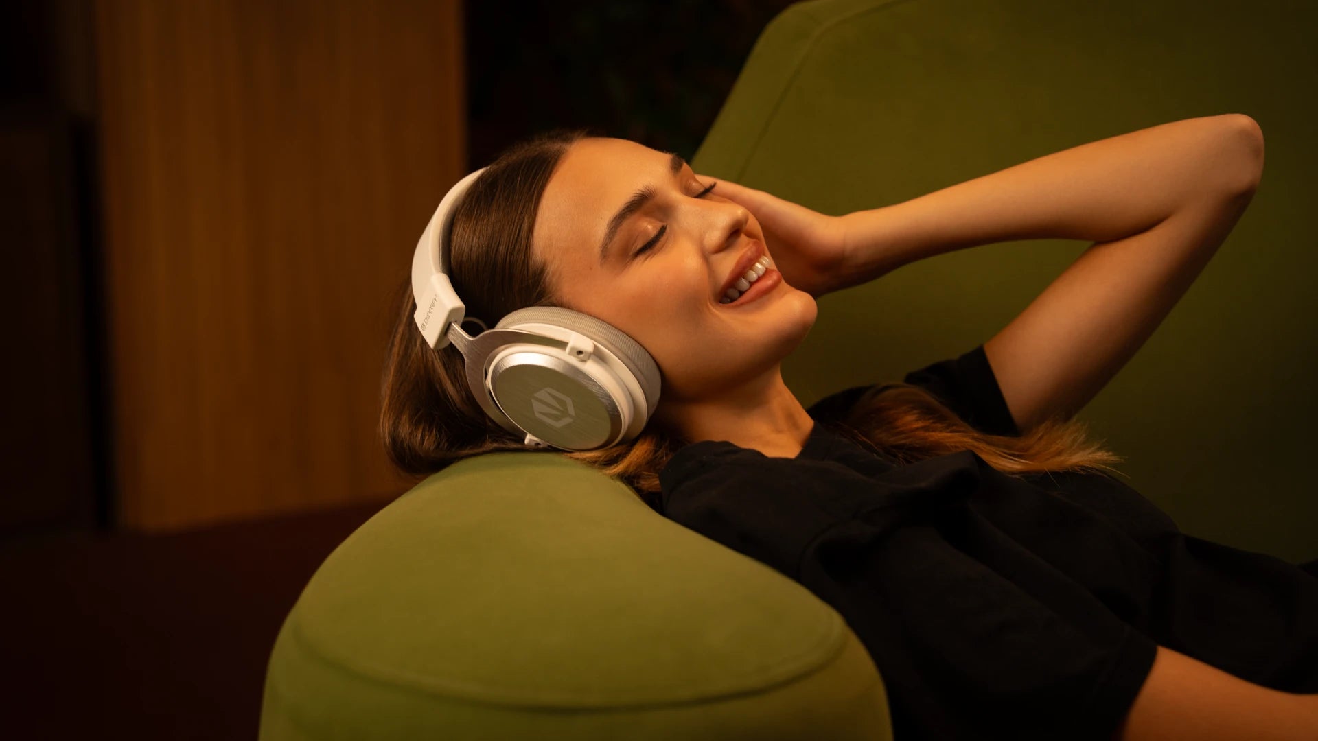Woman resting on a sofa while wearing the ENDORFY Viro Infra Wireless Onyx White headphones