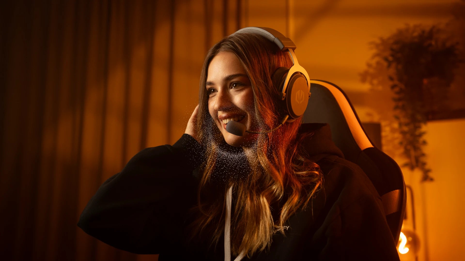 Woman using the ENDORFY Viro Infra Wireless Alt Gray headphones with the boom microphone attached while working at her computer.