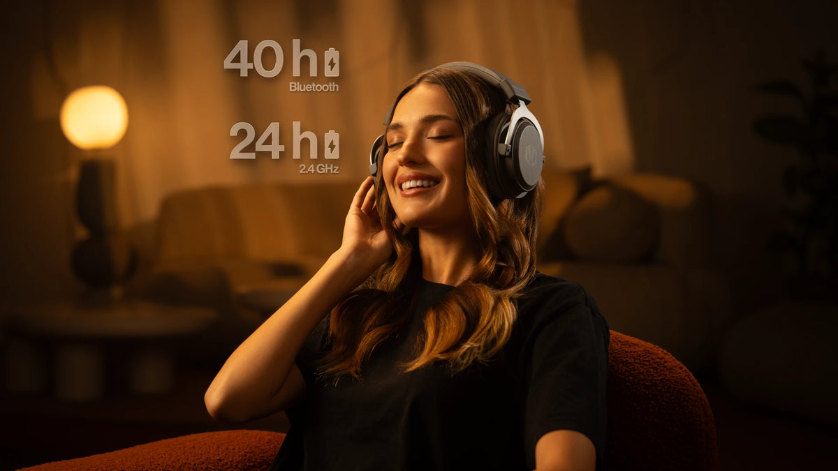 Woman sitting in a chair wearing the ENDORFY Viro Infra Wireless Alt Gray headphones.