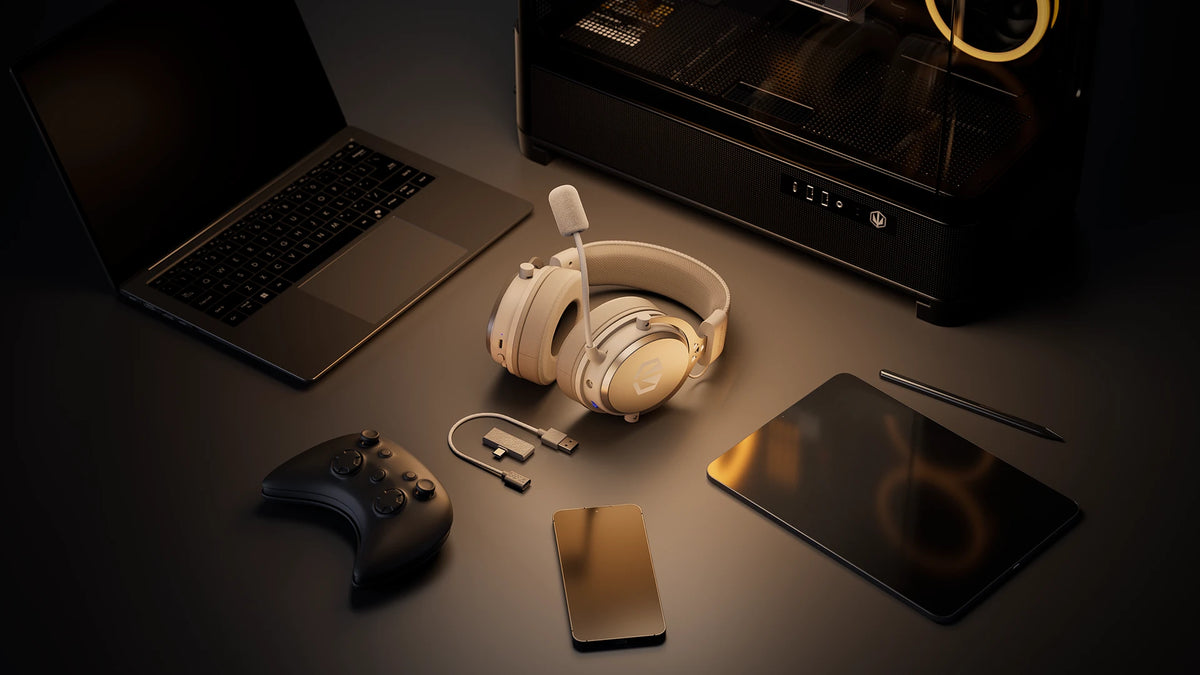 ENDORFY Viro Wireless Onyx White headphones lying on a desk surrounded by portable devices – a laptop, gamepad, smartphone and tablet – and a desktop computer