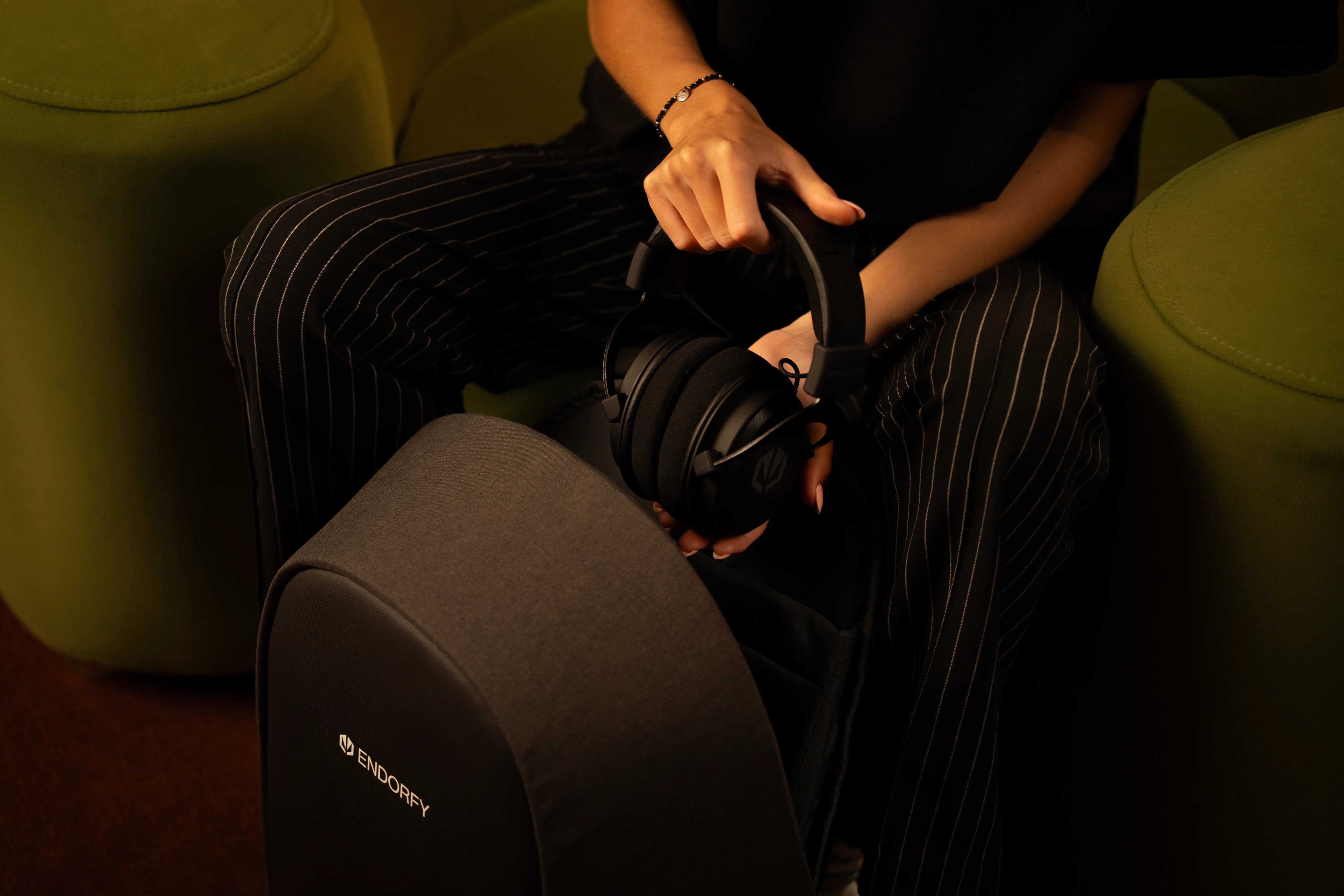 Woman packing the ENDORFY Viro Infra Wireless gaming headphones into her backpack, showcasing their lightweight design