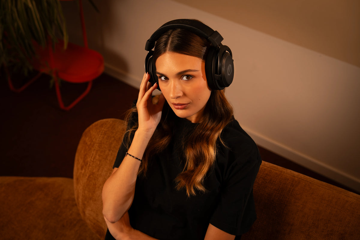 Woman looking directly at the camera while using the on-ear multimedia controls of the ENDORFY Viro Infra Wireless gaming headphones